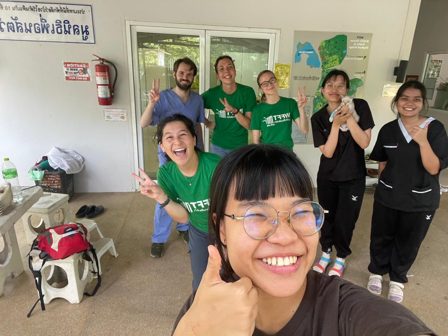 A group of smiling students pose for a selfie. 