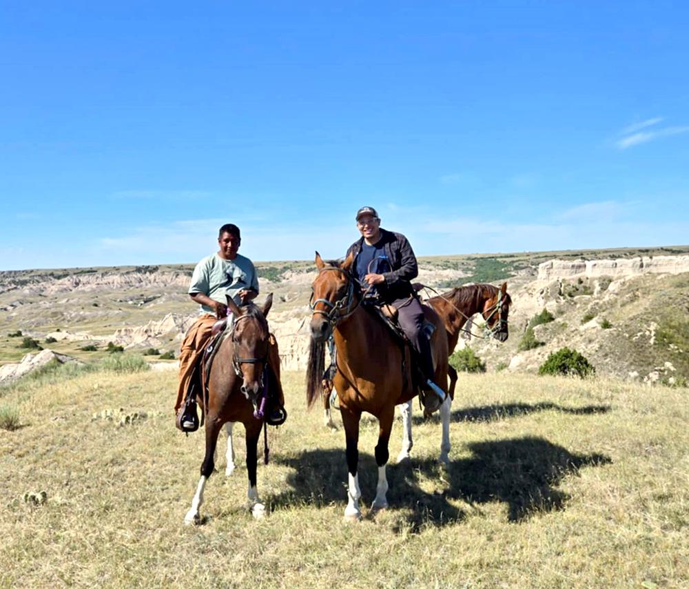 Two people riding horses.