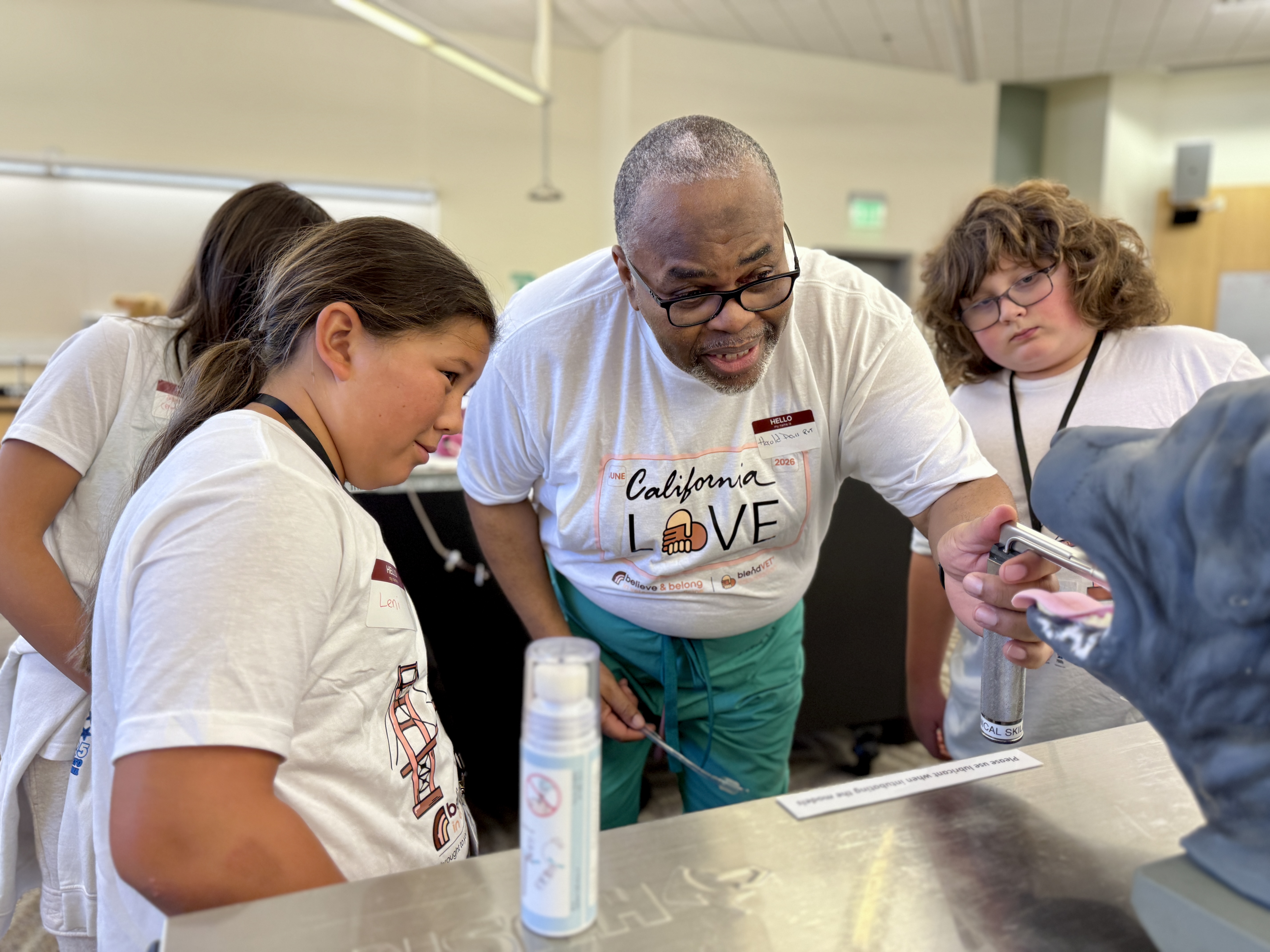Instructor pointing to lab sink while students watch attentively
