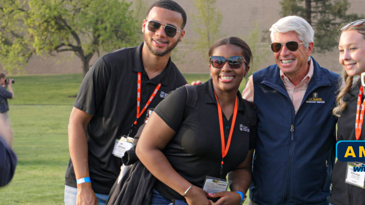 Dean Mark Stetter posing with SAVMA attendees outside on the lawn.