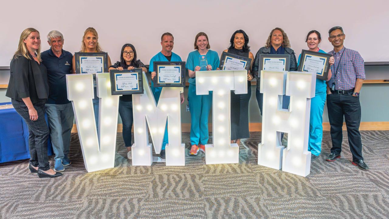 group photo with large lighted letters that spell VMTH