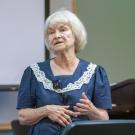 Dr. Lynette Hart standing in front of a screen and podium in a lecture hall.