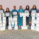 group photo with large lighted letters that spell VMTH